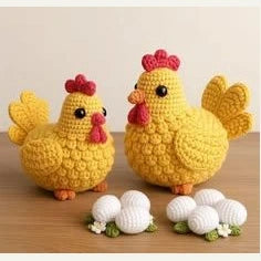 Deux poules jaunes au crochet avec des œufs blancs