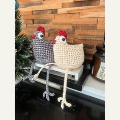 Deux poules blanche et grise au crochet, assises sur un petit banc